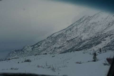 1990 Chevrolet Suburban - A vast, snow-covered mountain dominates the landscape under a muted, overcast sky.