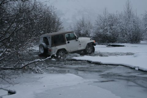 1990 Chevrolet Suburban - Jeep Wrangler navigating icy terrain in a snowy landscape.