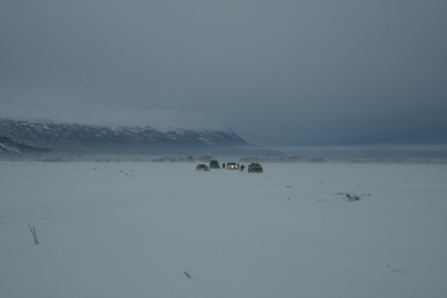 Group of SUVs in a snowy landscape with a mountain range in the background