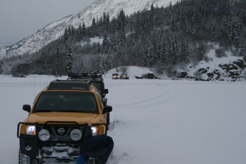 1990 Chevrolet Suburban - Multiple vehicles parked in a snowy, mountainous landscape with pine trees.