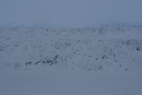 1990 Chevrolet Suburban - A vast expanse of snow-covered mountains and a glacier under a hazy sky.