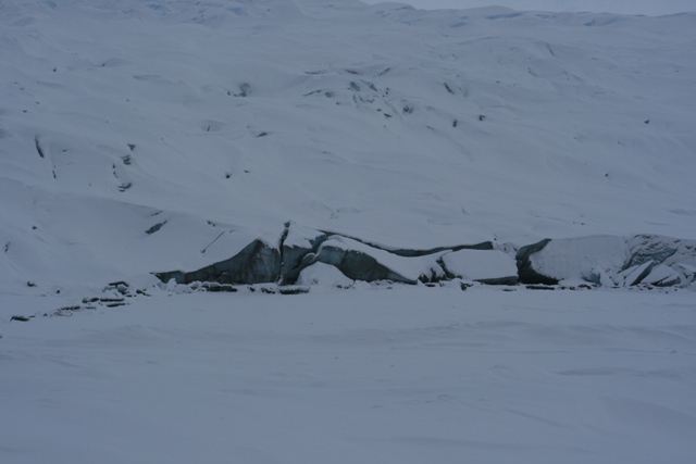 Snowy landscape with a glacier showing fractured ice formations