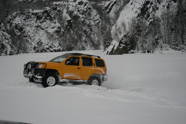 Yellow SUV driving through snow with a bull bar