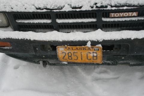 1990 Chevrolet Suburban - A Toyota truck's front grille and license plate are partially covered in snow.