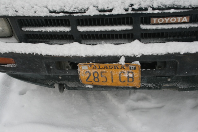 Toyota grille covered in snow with an Alaska license plate reading 2851 CB