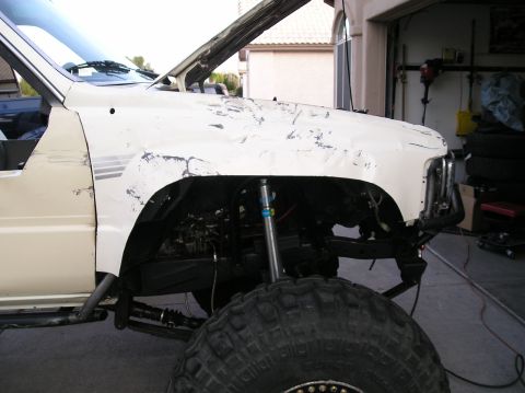 1986 Toyota Hilux - Front fender and suspension of a modified 1986 Toyota Hilux with large off-road tires.
