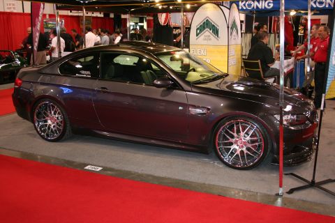 Dark gray coupe with custom chrome wheels and red accents