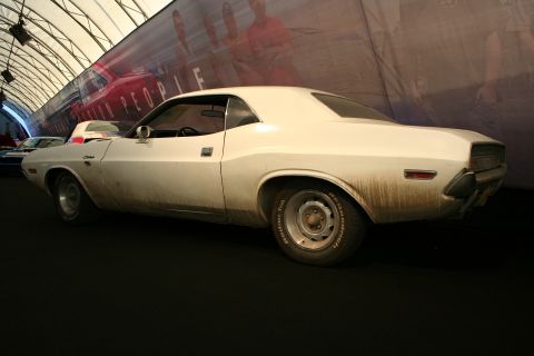 White 1970s coupe with Challenger badging, rear three-quarter view