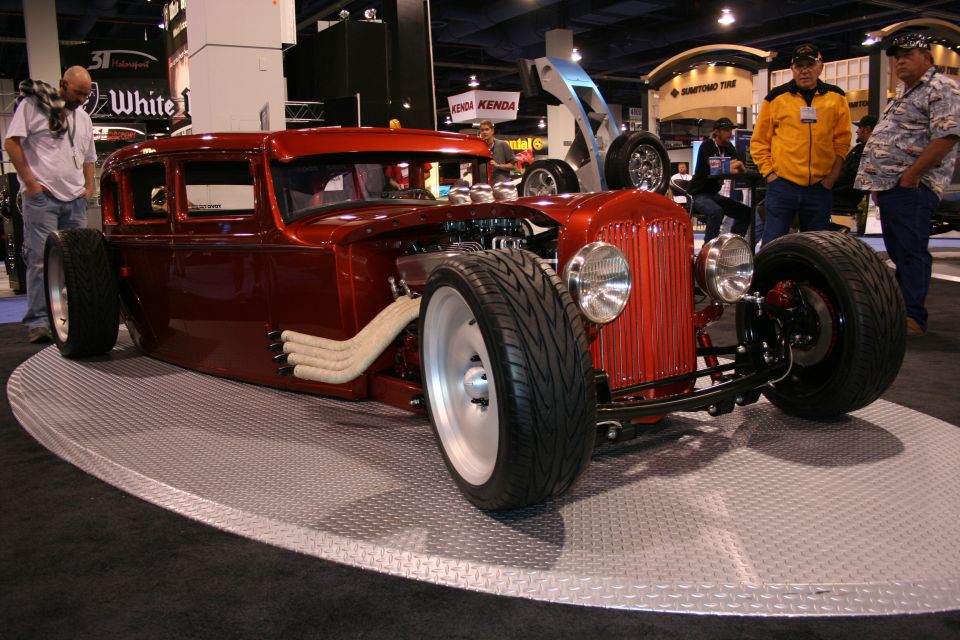 Red hot rod sedan with exposed engine and custom exhaust pipes