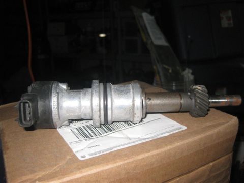 1971 Ford Mustang - A close-up view of a vehicle distributor part resting on a cardboard box with a shipping label.