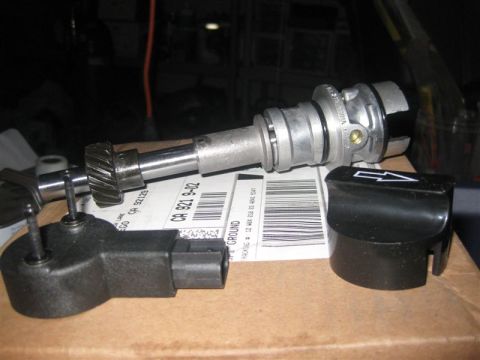 1971 Ford Mustang - Close-up of automotive distributor and sensor components resting on a shipping label with visible tracking information.