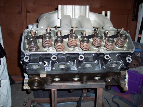 1971 Ford Mustang - Engine block with valve train components visible, mounted on a stand in a workshop.