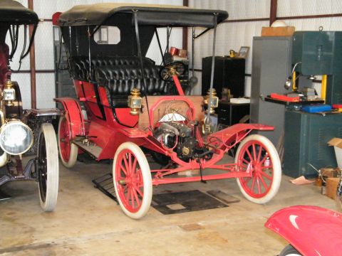 1909 Ford Model T - This 1909 Ford Model T touring car is red with a black fabric top and white-walled tires.