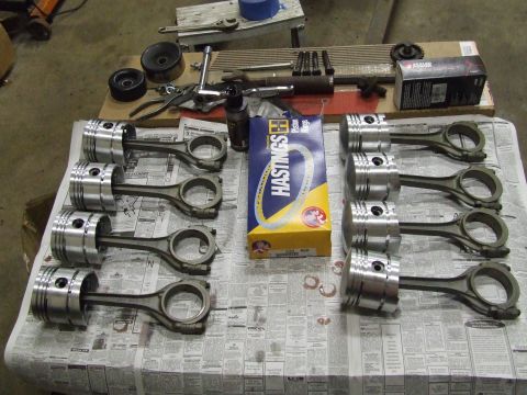1967 Ford Bronco - Engine parts including pistons, connecting rods, and piston rings are laid out on a table.