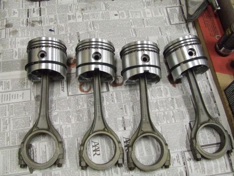1967 Ford Bronco - Engine pistons and connecting rods are laid out on a surface covered with newspaper, ready for assembly or inspection.