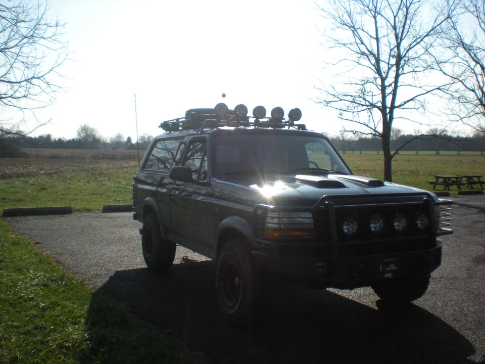 1993 Ford Bronco with roof rack, off-road lights, and brush guard parked outdoors