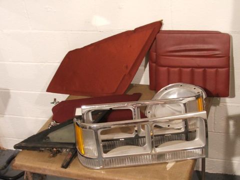 1989 Ford Bronco II - Various interior and exterior parts for a 1989 Ford Bronco II are laid out on a table.