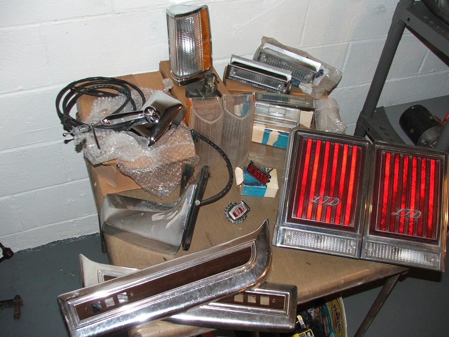 Pile of car parts including tail lights labeled LTD, side mirror, and trim pieces