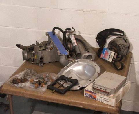 1989 Ford Bronco II - Various engine components including a carburetor, injectors, alternator, and an engine control unit are laid out.