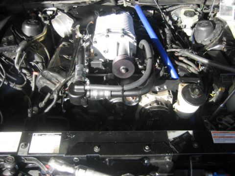 1996 Ford Thunderbird - Engine bay view showing a supercharger installation with various hoses and wiring.