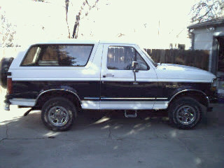 1994 Ford Bronco - This two-tone Ford Bronco is shown from the side, parked in a driveway.