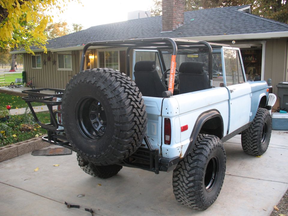 Lifted early Ford Bronco with rear tire carrier in a driveway