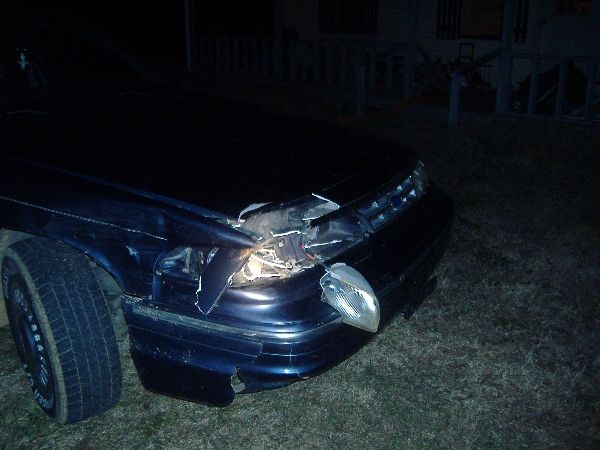 Damaged front end of a dark blue 1997 Ford Crown Victoria