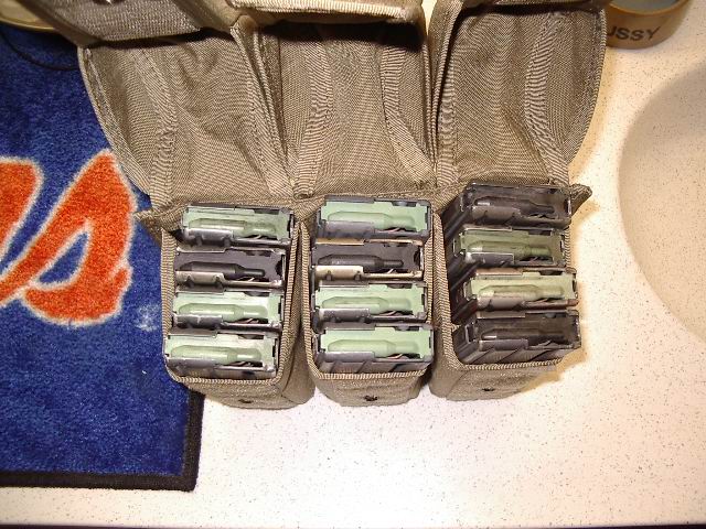 Tactical pouch holding multiple rifle magazines. A blue and orange towel is visible to the left
