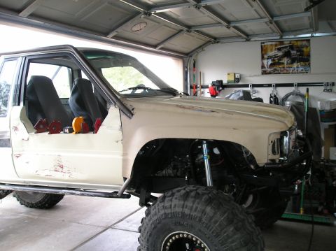 1986 Toyota Hilux - This modified pickup truck is undergoing repairs or customization in a garage setting.