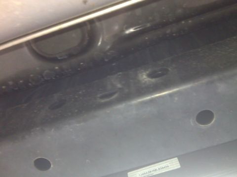 2008 Jeep Wrangler - A close-up view of the undercarriage of a vehicle, showing structural components and a website watermark.