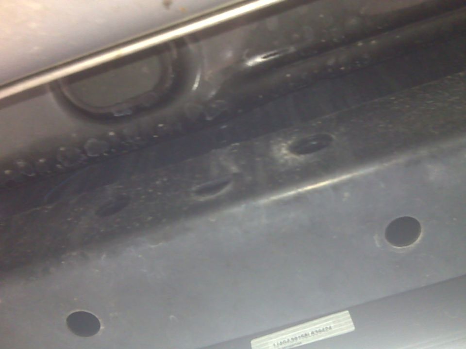Underside of a vehicle frame with some holes and a Supermotors.net watermark