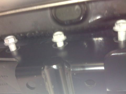 2008 Jeep Wrangler - Close-up view of the undercarriage of a vehicle, focusing on bolts and structural components.