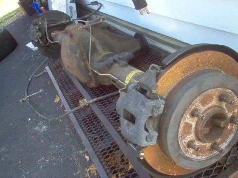2007 Ford Mustang - A rear axle assembly with brake components is shown, resting on a metal grate.