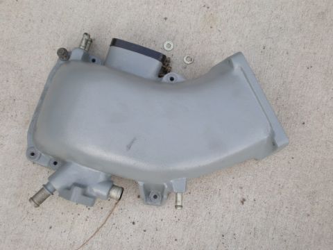 2007 Ford Mustang - Gray intake manifold with black cap and metal fittings, likely for an engine component.