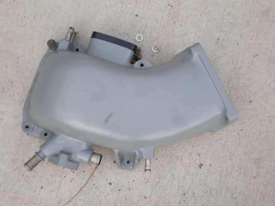 Gray intake manifold with black cap and metal fittings