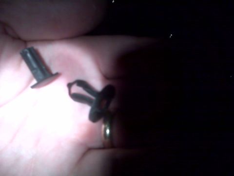 2008 Jeep Wrangler - Two black plastic automotive clips are held in a hand, one a push-pin style and the other a clip fastener.