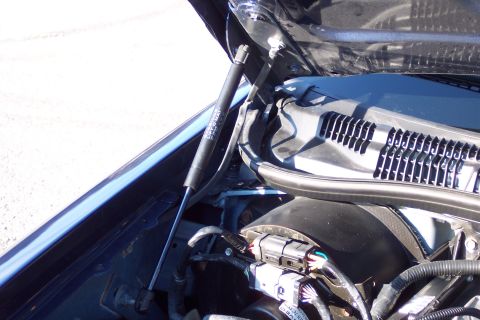 2001 Ford Crown Victoria - Close-up view of a blue car's engine bay, focusing on the hood strut labeled 'LIFTO-WAY'.