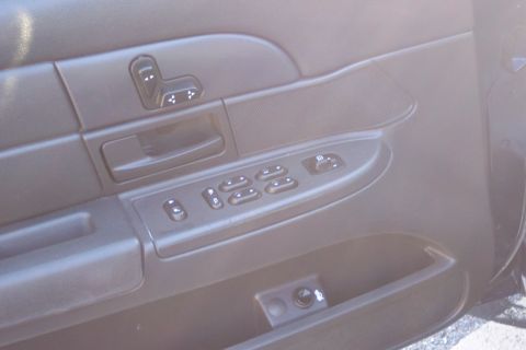 2001 Ford Crown Victoria - Interior view of a black car door panel, displaying power controls for windows and seats.
