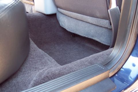 2001 Ford Crown Victoria - Close-up of the interior floor and lower seat area of a vehicle.