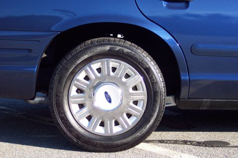 2001 Ford Crown Victoria - Rear wheel and fender of a blue 2001 Ford Crown Victoria.