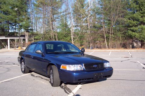 2001 Ford Crown Victoria - This 2001 Ford Crown Victoria sedan is shown in a three-quarter front view, parked in an empty lot.