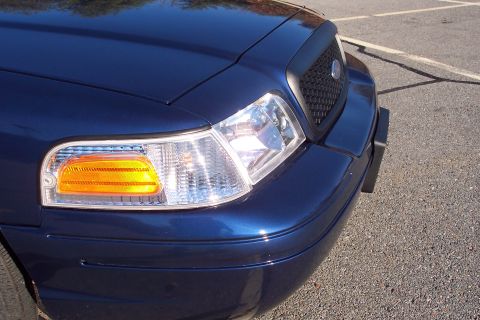 2001 Ford Crown Victoria - Front corner view of a dark blue 2001 Ford Crown Victoria, parked on asphalt.
