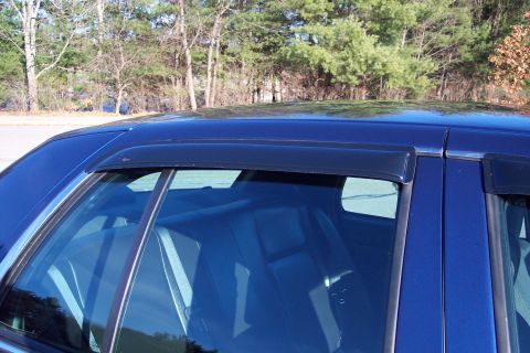 2001 Ford Crown Victoria - The rear interior of a blue sedan is visible through the windows, which are equipped with dark-colored visors.
