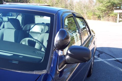 2001 Ford Crown Victoria - Interior view of a blue 2001 Ford Crown Victoria, showing the steering wheel, dashboard, and side mirror.