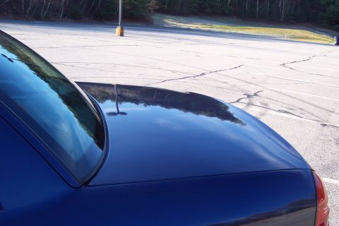 2001 Ford Crown Victoria - The rear quarter panel and trunk lid of a dark blue 2001 Ford Crown Victoria are visible in this image.
