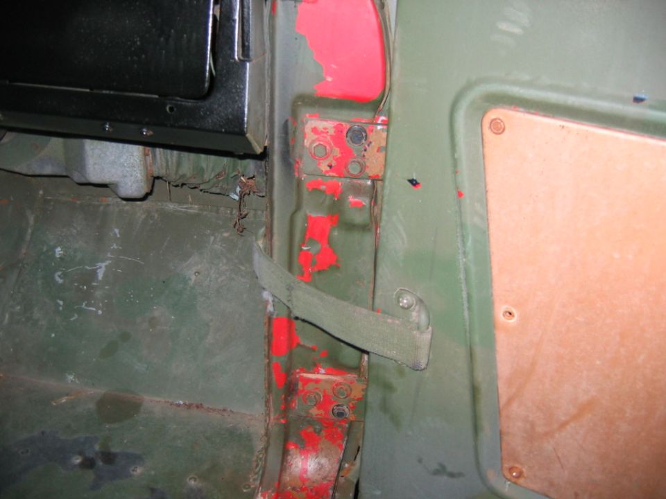 Green door jamb with hinge plates, check strap and red paint showing through