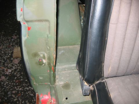 1992 Ford Mustang - Close-up through a doorless opening showing the green-painted door sill, body seam and floor of a project 4x4, with red paint spatter, surf…