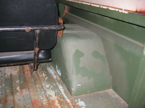 1992 Ford Mustang - The interior of an older vehicle shows a worn seat and a heavily rusted floor panel.