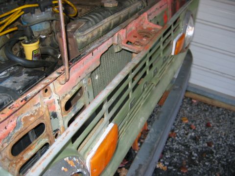 1992 Ford Mustang - Front view of a 1970 Ford Bronco's grille and engine bay, showing signs of wear.