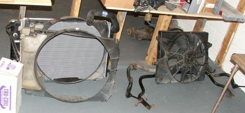 1989 Ford Bronco II - Vehicle radiator and fan components are laid out on the floor next to a box.